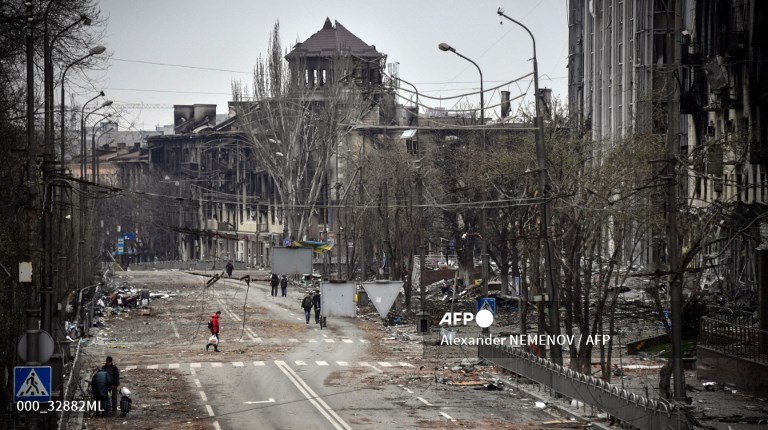 Orang-orang berjalan di jalan Mariupol pada 12 April 2022.